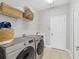 Bright laundry room with modern washer, dryer, and ample shelving at 13853 Siena Loop, Lakewood Ranch, FL 34202