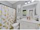 Clean bathroom with white vanity, toilet, and pineapple shower curtain at 13853 Siena Loop, Lakewood Ranch, FL 34202