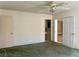 A bedroom with green carpet, ceiling fan, and doorway to bathroom at 6613 Blue Heron S Dr, St Petersburg, FL 33707