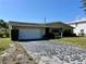 Charming single-story home features an attached garage, well-kept landscaping, and a welcoming entrance at 6613 Blue Heron S Dr, St Petersburg, FL 33707