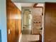 Hallway with tile flooring and wood paneling, leading to other rooms in the house at 6613 Blue Heron S Dr, St Petersburg, FL 33707