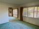 Cozy living room with a door, large windows and green carpet, creating a bright and inviting space at 6613 Blue Heron S Dr, St Petersburg, FL 33707