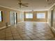 Open-concept living area with tile flooring, ceiling fan, and sliding glass door at 6613 Blue Heron S Dr, St Petersburg, FL 33707