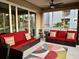 Relaxing balcony furnished with red wicker sofas and colorful pillows at 395 Aruba Cir # 102, Bradenton, FL 34209