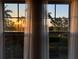 Window view of sunset over water with palm trees at 395 Aruba Cir # 102, Bradenton, FL 34209