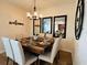 Elegant dining room with a wood table and six chairs, mirrors and decorative wall art at 395 Aruba Cir # 102, Bradenton, FL 34209