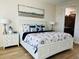 Main bedroom with king bed, en-suite bathroom access, and coastal decor at 395 Aruba Cir # 102, Bradenton, FL 34209