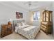 Comfortable bedroom with a queen-size bed and antique dresser at 750 N Tamiami Trl # 1115, Sarasota, FL 34236