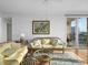 Sunlit living room featuring comfortable sofas and a glass coffee table at 750 N Tamiami Trl # 1115, Sarasota, FL 34236