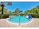 Community pool area with lounge chairs, umbrellas, and palm trees at 395 Aruba Cir # 102, Bradenton, FL 34209