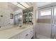 Bathroom with a shower, sink, and white cabinetry at 6915 Chancery Pl, University Park, FL 34201