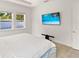 Comfortable bedroom with mounted TV and ample natural light at 1800 Robinhood St, Sarasota, FL 34231