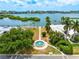 Stunning aerial view of a waterfront home with lush landscaping, a water fountain, and a picturesque coastal backdrop at 5900 Driftwood Ave, Sarasota, FL 34231