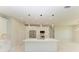 Modern kitchen with white cabinetry, large island, and stylish lighting fixtures at 8380 Malcolm Ave, North Port, FL 34287
