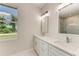 Elegant bathroom with double vanity, quartz countertops and large mirror at 8380 Malcolm Ave, North Port, FL 34287
