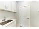 Laundry room with white cabinets, quartz countertop and utility sink at 8380 Malcolm Ave, North Port, FL 34287