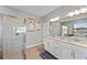 Bright bathroom featuring double sinks with granite counters and a glass enclosed shower at 15739 Barefoot Beach Dr, Bradenton, FL 34211