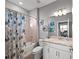 Cozy bathroom features a shower-tub combo, stylish vanity, and beach-themed decor at 15739 Barefoot Beach Dr, Bradenton, FL 34211