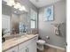 Well-lit bathroom with a granite vanity, framed mirror, towel rack, and walk-in shower at 15739 Barefoot Beach Dr, Bradenton, FL 34211