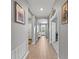Hallway with white trim and light wood floors featuring recessed lights, artwork, and access to other rooms at 15739 Barefoot Beach Dr, Bradenton, FL 34211