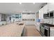 Modern open kitchen features sleek white cabinets and stainless steel appliances at 15739 Barefoot Beach Dr, Bradenton, FL 34211