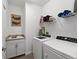 Functional laundry room with granite countertop, sink, storage shelves, washer, and dryer at 15739 Barefoot Beach Dr, Bradenton, FL 34211