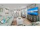 Spacious open concept living room, adjacent to modern kitchen, featuring large TV and light-filled windows with decorative curtains at 15739 Barefoot Beach Dr, Bradenton, FL 34211
