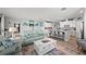 Open-concept living room with tile floors, a comfortable sofa, and a modern kitchen with a breakfast bar at 15739 Barefoot Beach Dr, Bradenton, FL 34211