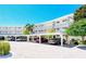 Exterior view of a modern condo building with ample parking at 100 Sands Point Rd # 324, Longboat Key, FL 34228