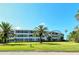 Curved building with balconies and lush lawn at 100 Sands Point Rd # 324, Longboat Key, FL 34228