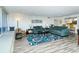 Open living space with teal sofas, wood-look floors, and a large rug at 100 Sands Point Rd # 324, Longboat Key, FL 34228
