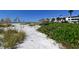 Beachfront walkway with lush landscaping and beach access at 100 Sands Point Rd # 324, Longboat Key, FL 34228