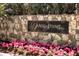 Sands Point community entrance with stone wall and flowers at 100 Sands Point Rd # 324, Longboat Key, FL 34228