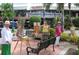 Three women painting outdoors in a plaza setting, surrounded by palm trees at 100 Sands Point Rd # 324, Longboat Key, FL 34228