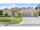 House exterior featuring a three-car garage and manicured lawn at 2479 Grandview Dr, North Port, FL 34288