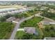 Neighborhood aerial view featuring a home with a screened pool, lush landscaping, and community lake at 2511 Stagnaro Rd, North Port, FL 34287