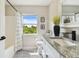 Bright bathroom featuring a vanity with a granite countertop and large window with a scenic view at 2511 Stagnaro Rd, North Port, FL 34287