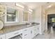 Bathroom showcasing vanity with dual sinks, granite countertops, and decorative mirrors at 2511 Stagnaro Rd, North Port, FL 34287