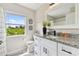 Bright bathroom featuring a vanity with a granite countertop and large window with a scenic view at 2511 Stagnaro Rd, North Port, FL 34287