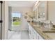 Bathroom with a granite countertop vanity, dual sinks, and scenic outdoor views at 2511 Stagnaro Rd, North Port, FL 34287