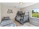 Cozy bedroom featuring a bunk bed, twin bed, and large window with views of the outdoors at 2511 Stagnaro Rd, North Port, FL 34287