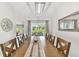 Bright dining room features a contemporary chandelier and a long wooden table with views of the outdoor area at 2511 Stagnaro Rd, North Port, FL 34287