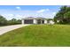 Inviting single-story home with a lush green lawn, complemented by a freshly paved driveway and a mature palm tree at 2511 Stagnaro Rd, North Port, FL 34287