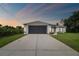Charming home with a well-manicured lawn and a long driveway leading to the garage at 2511 Stagnaro Rd, North Port, FL 34287