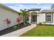 Charming home entrance with colorful landscaping, walkway, and freshly manicured lawn at 2511 Stagnaro Rd, North Port, FL 34287