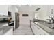 Bright kitchen features white cabinets, granite countertops, stainless appliances, and gray wood flooring at 2511 Stagnaro Rd, North Port, FL 34287
