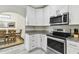 Bright kitchen features white cabinets, stainless steel appliances, and granite countertops near dining area at 2511 Stagnaro Rd, North Port, FL 34287