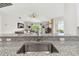 View of the living room from the kitchen, highlighting the granite countertops and stainless steel sink at 2511 Stagnaro Rd, North Port, FL 34287