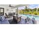 Outdoor patio area with comfortable seating, dining space, and a view of the screened-in pool at 2511 Stagnaro Rd, North Port, FL 34287