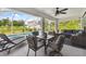 Screened in patio with a dining table, plush seating, and a view of the pool and backyard at 2511 Stagnaro Rd, North Port, FL 34287